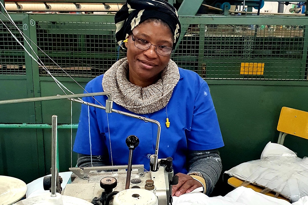 Romatex employee sitting behind a sewing machine