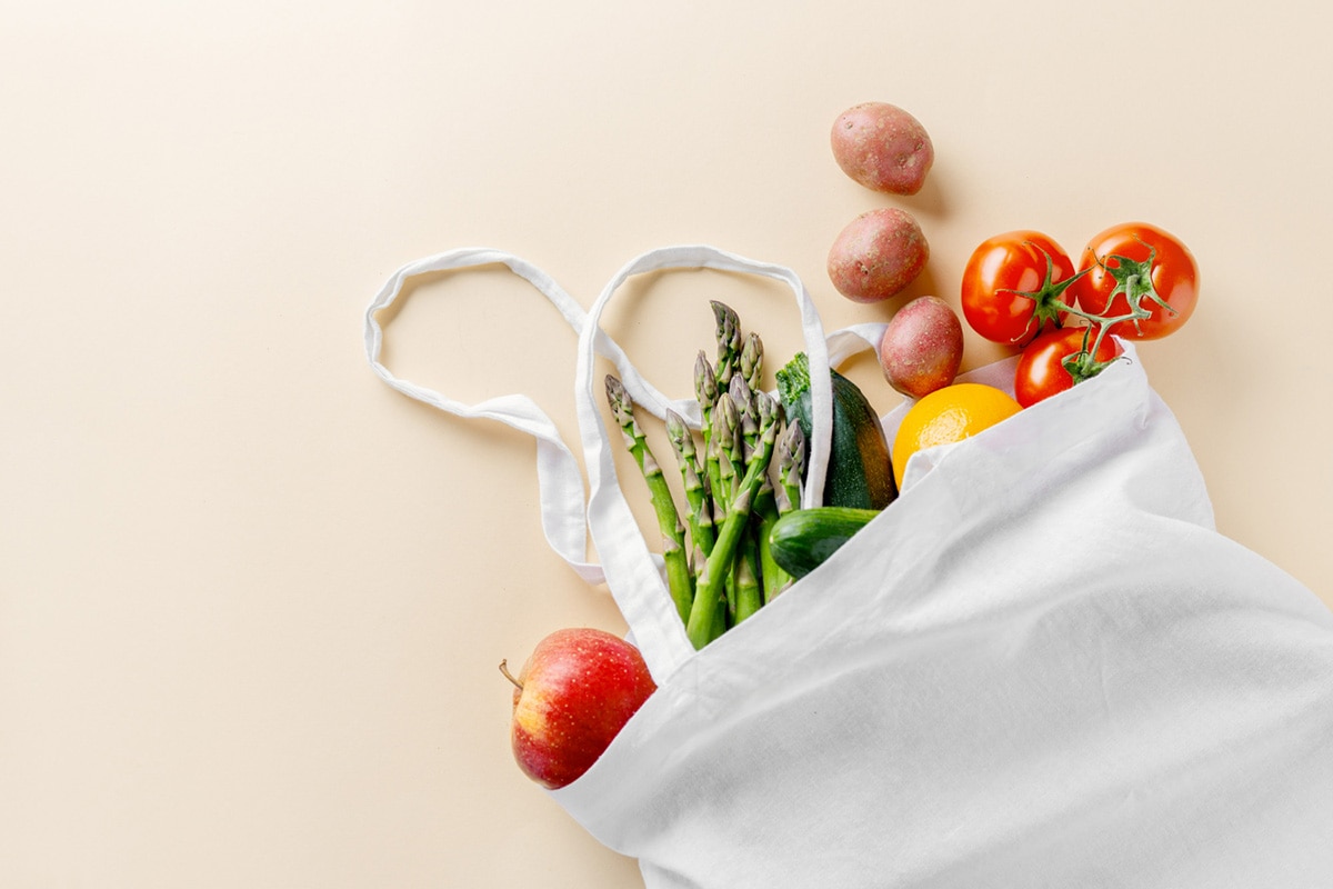Recycled shopping bag filled with fresh vegetables